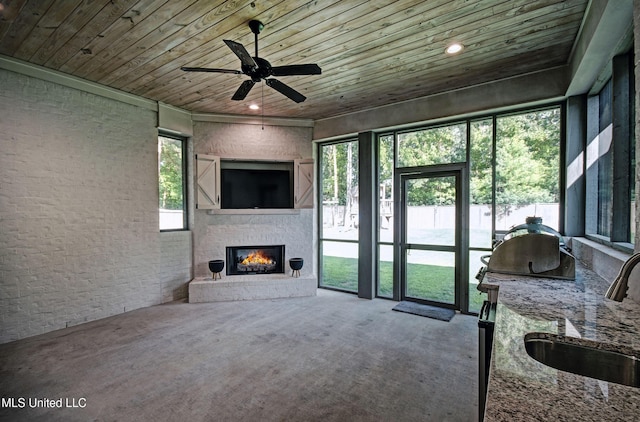 220 S Woodcreek Rd, Madison, MS 39110 - living area with wood ceiling, a warm lit fireplace, carpet floors, and a ceiling fan