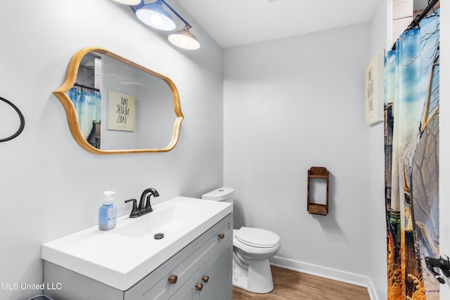 bathroom featuring wood-type flooring, vanity, and toilet