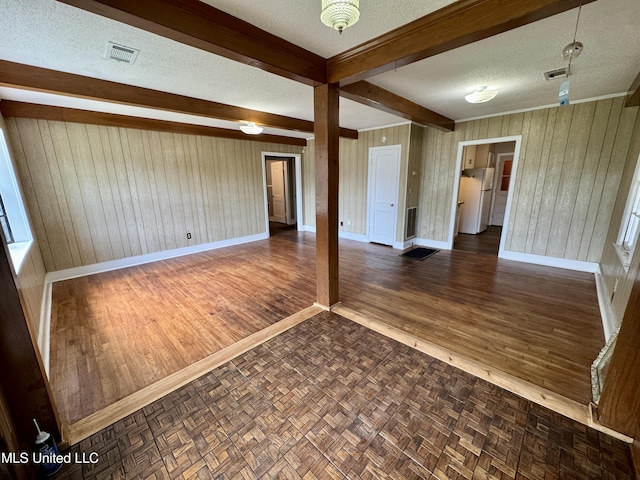 221 N Third Ave, Cleveland, MS 38732 - empty room with a textured ceiling, wood walls, baseboards, beamed ceiling, and parquet floors