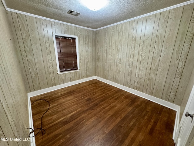 221 N Third Ave, Cleveland, MS 38732 - spare room featuring a textured ceiling, dark wood-style flooring, wooden walls, baseboards, and crown molding
