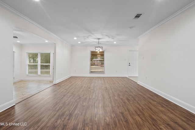 unfurnished living room with an inviting chandelier, wood-type flooring, and ornamental molding