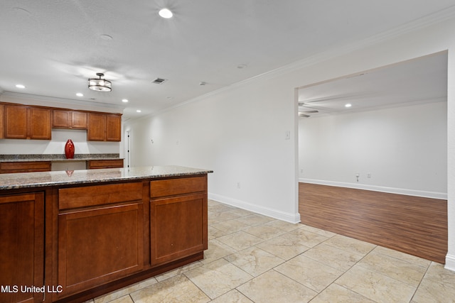 kitchen featuring light stone counters, light hardwood / wood-style flooring, ceiling fan, and ornamental molding