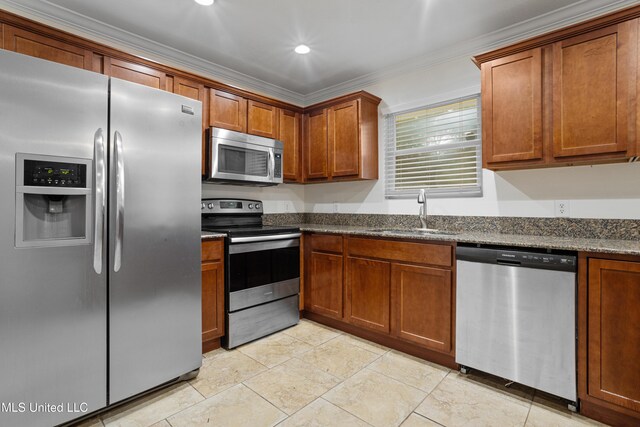 13901 Plano Rd, Ocean Springs, MS 39564 - kitchen featuring stainless steel appliances, a sink, crown molding, brown cabinetry, and dark stone countertops