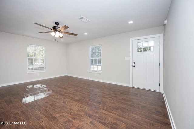 interior space with a healthy amount of sunlight, ceiling fan, and dark wood-type flooring