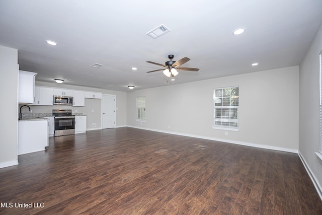 unfurnished living room featuring ceiling fan, dark wood-type flooring, and sink