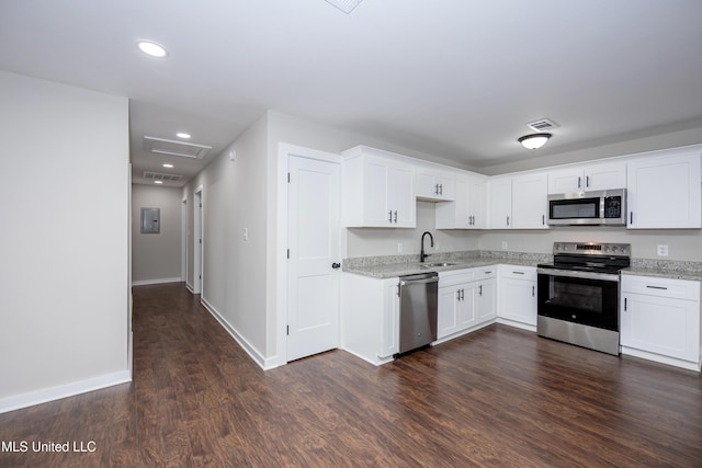 kitchen featuring sink, light stone counters, dark hardwood / wood-style flooring, white cabinets, and appliances with stainless steel finishes