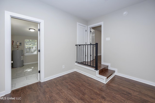 hallway with dark hardwood / wood-style flooring and water heater