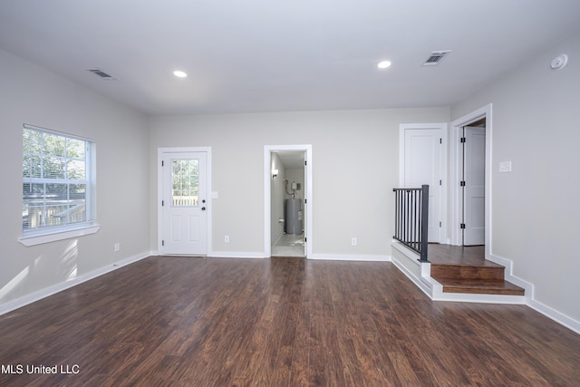 spare room with dark hardwood / wood-style floors and water heater