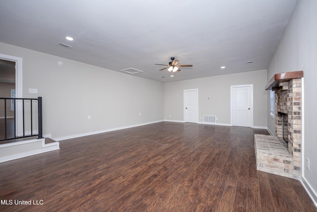 unfurnished living room with ceiling fan, dark hardwood / wood-style floors, and a brick fireplace