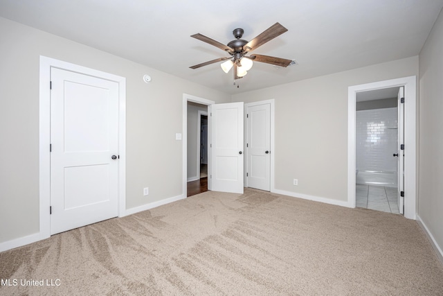 unfurnished bedroom featuring carpet flooring, ceiling fan, and ensuite bathroom