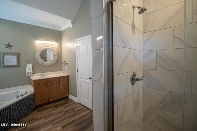 bathroom with vanity, hardwood / wood-style floors, crown molding, and plus walk in shower