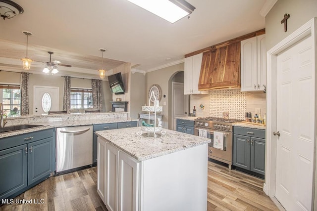 kitchen featuring pendant lighting, appliances with stainless steel finishes, white cabinetry, plenty of natural light, and a kitchen island