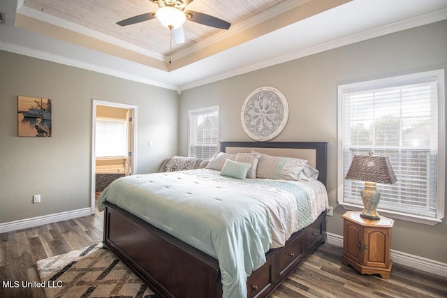 bedroom with connected bathroom, ornamental molding, dark hardwood / wood-style floors, a raised ceiling, and ceiling fan