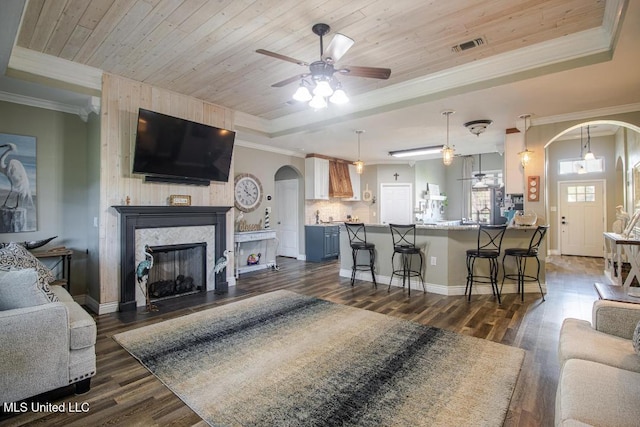 living room with wood ceiling, ornamental molding, dark hardwood / wood-style floors, and a raised ceiling