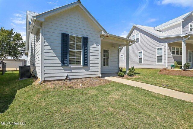 view of front of house with a front yard and central AC unit