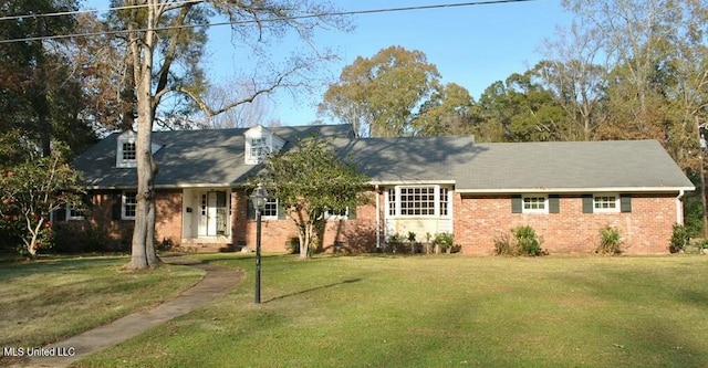 cape cod house with brick siding and a front yard