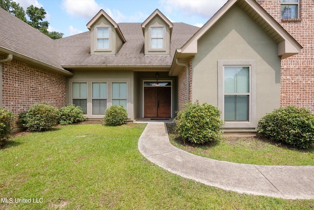 view of exterior entry with a lawn