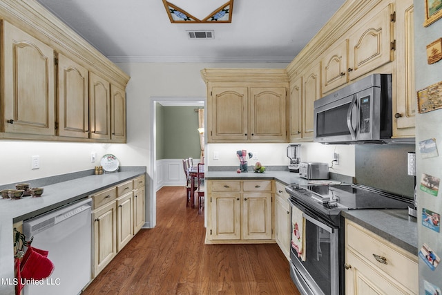 kitchen featuring dark wood-type flooring, appliances with stainless steel finishes, crown molding, and light brown cabinets