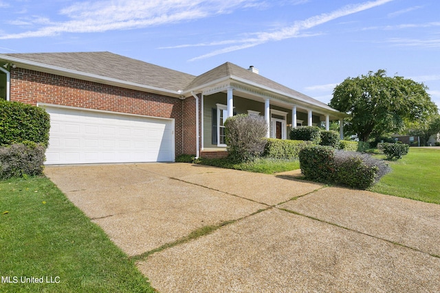 view of front facade with covered porch, a front yard, and a garage