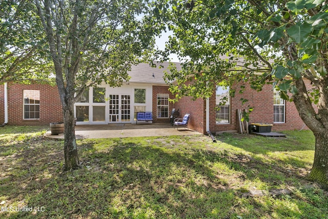 rear view of house featuring french doors, a yard, a patio area, and central AC unit