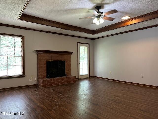 1613 Springridge Dr, Jackson, MS 39211 - unfurnished living room with a textured ceiling, crown molding, ceiling fan, a raised ceiling, and wood finished floors