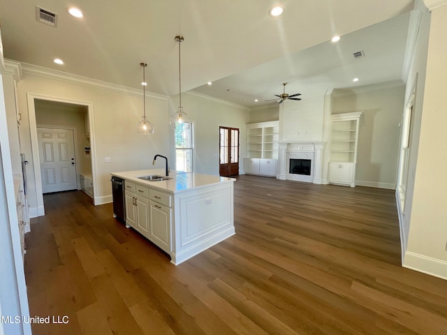 kitchen with a center island with sink, ceiling fan, white cabinetry, dark wood-type flooring, and decorative light fixtures