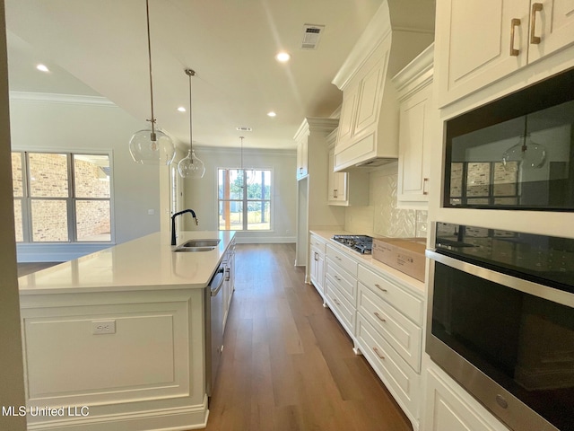 kitchen with sink, white cabinetry, pendant lighting, dark hardwood / wood-style floors, and a kitchen island with sink