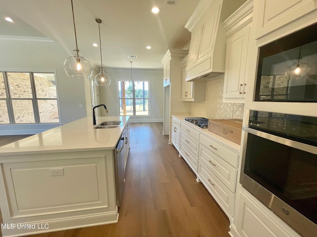 352 Wellstone Pl, Madison, MS 39110 - kitchen with stainless steel appliances, a sink, crown molding, light countertops, and custom exhaust hood