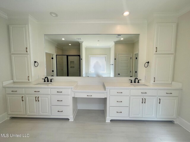 bathroom featuring vanity, ornamental molding, a shower with shower door, and tile patterned flooring