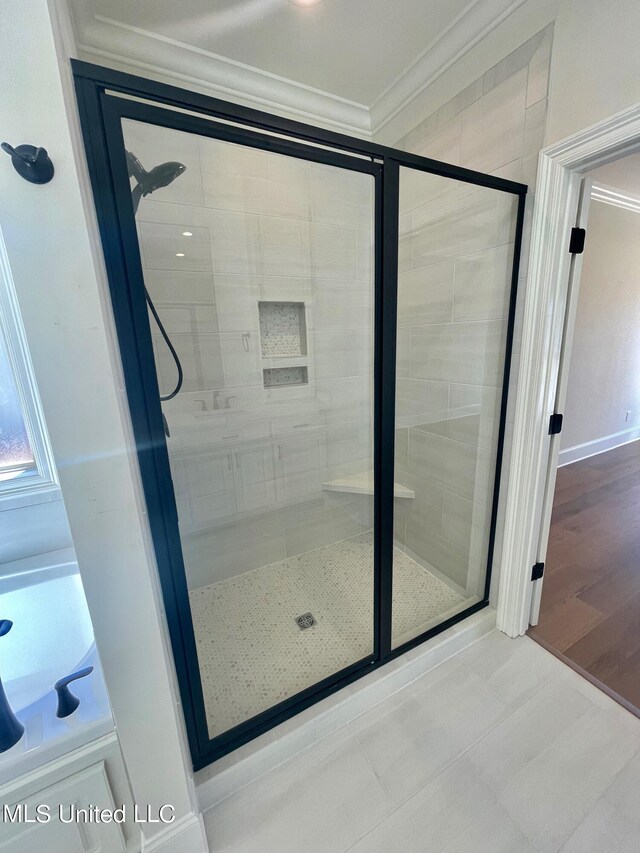 bathroom with a shower with door, crown molding, and hardwood / wood-style floors