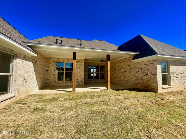 rear view of property featuring a patio area and a yard