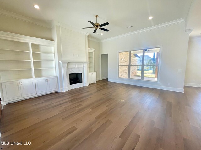 unfurnished living room featuring ornamental molding, a high end fireplace, hardwood / wood-style flooring, and ceiling fan