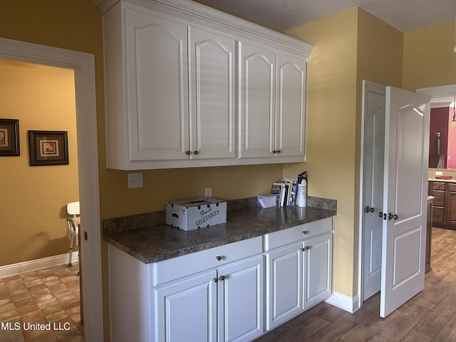 8101 Pecan Ridge Dr, Moss Point, MS 39562 - kitchen featuring dark countertops, white cabinetry, and wood finished floors