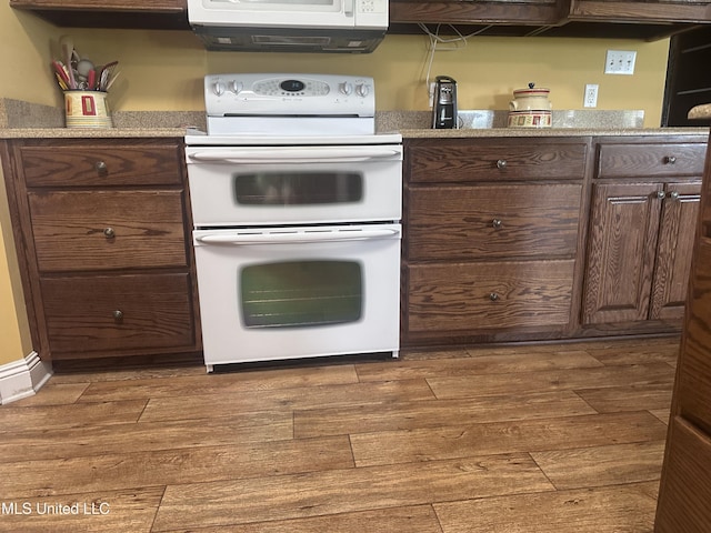 8101 Pecan Ridge Dr, Moss Point, MS 39562 - kitchen with range with two ovens, wood finished floors, light countertops, and dark brown cabinets