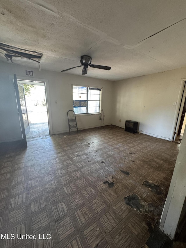 unfurnished room with ceiling fan and a textured ceiling