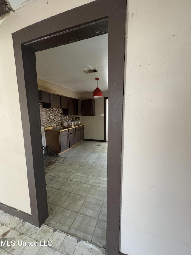 interior space with dark brown cabinets and decorative backsplash