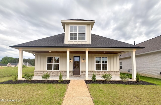 bungalow featuring covered porch, board and batten siding, brick siding, and a shingled roof