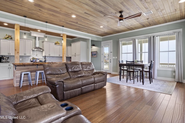 living room with crown molding, dark wood-type flooring, and wooden ceiling