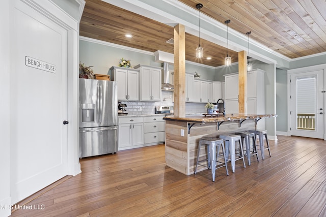 kitchen with crown molding, tasteful backsplash, wood ceiling, and stainless steel refrigerator with ice dispenser