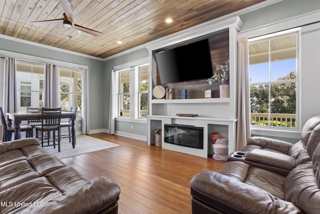 living area featuring a glass covered fireplace, wood-type flooring, wood ceiling, and ornamental molding