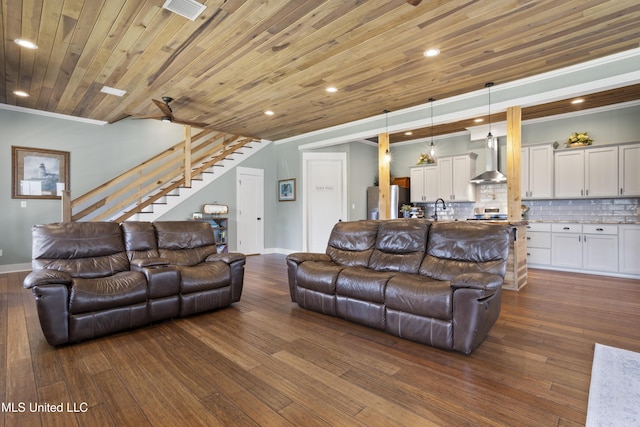 living room with dark wood-type flooring, wooden ceiling, stairs, and crown molding