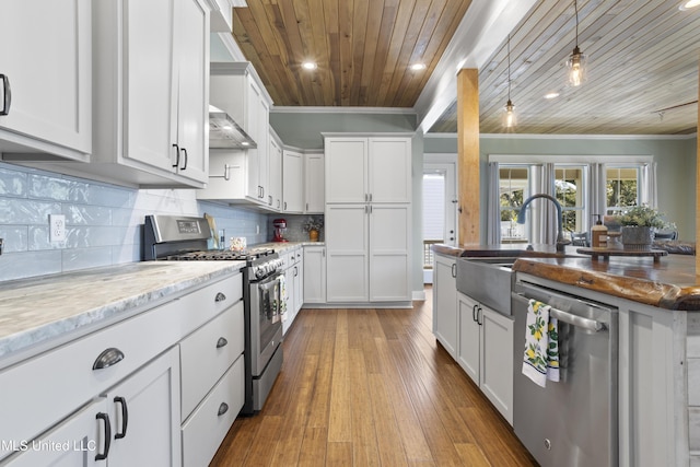 kitchen featuring ornamental molding, appliances with stainless steel finishes, white cabinets, decorative backsplash, and wood ceiling