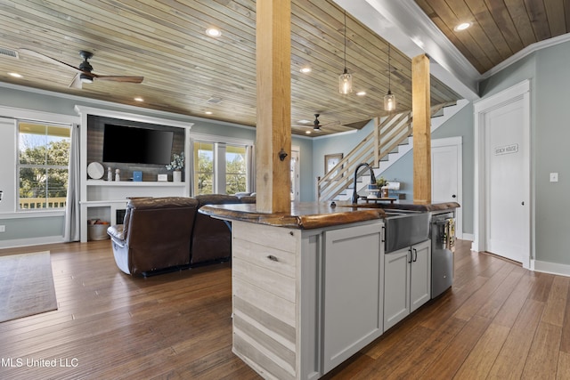 kitchen with a sink, crown molding, wood ceiling, dark countertops, and open floor plan