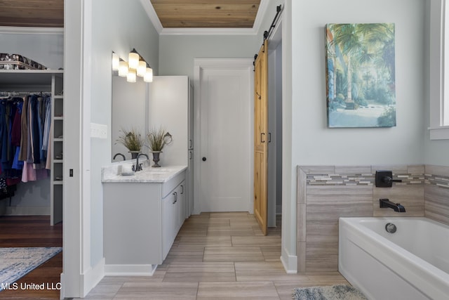 bathroom with a walk in closet, wood tiled floor, a garden tub, ornamental molding, and vanity