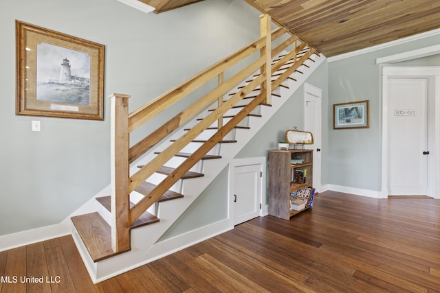 staircase featuring ornamental molding, baseboards, and hardwood / wood-style floors