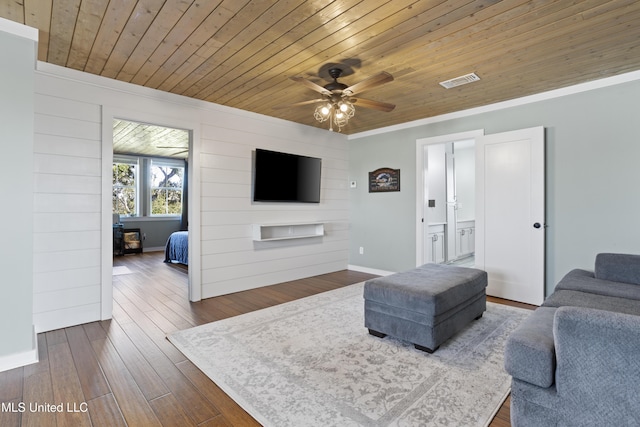 living room featuring a ceiling fan, visible vents, dark wood-style flooring, wood ceiling, and crown molding