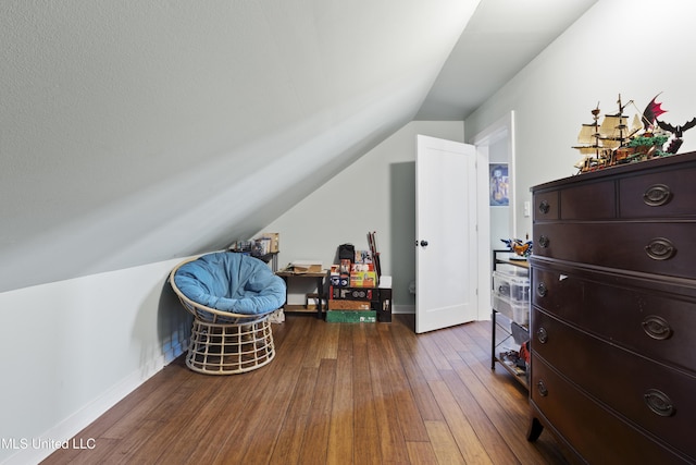 interior space with hardwood / wood-style flooring, baseboards, and lofted ceiling