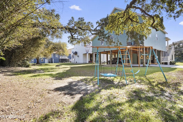 rear view of property with stairway, a lawn, and a carport