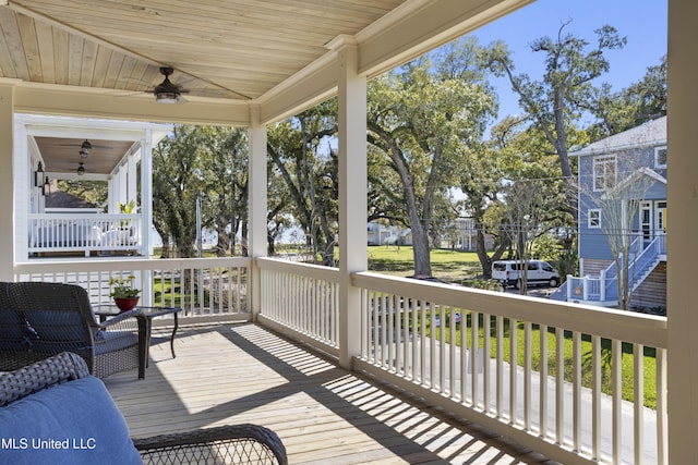 wooden terrace with a porch and ceiling fan