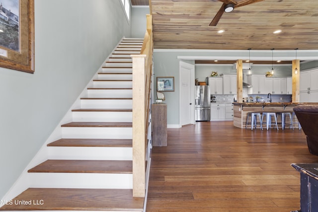 stairway with baseboards, wood ceiling, recessed lighting, wood finished floors, and a ceiling fan